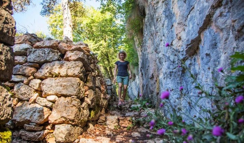 escursionista che attraversa un passaggio del trekking in Trentino Forra del lupo