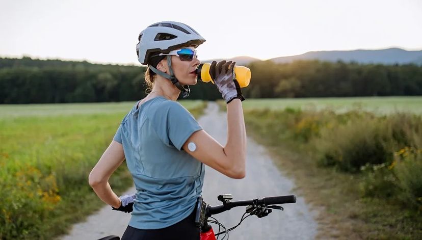 donna ciclista beve mentre fa sport in bici con dispositivo diabete