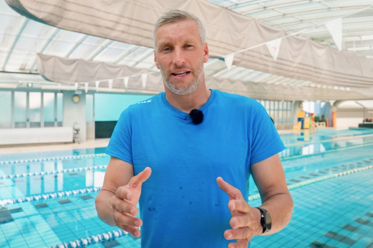 Daniel Hofer parla alla camera a bordo vasca in una piscina coperta